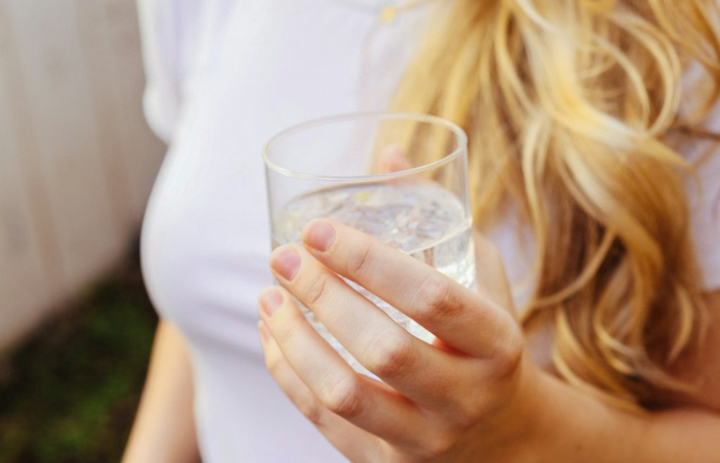 žena drži čašu vode